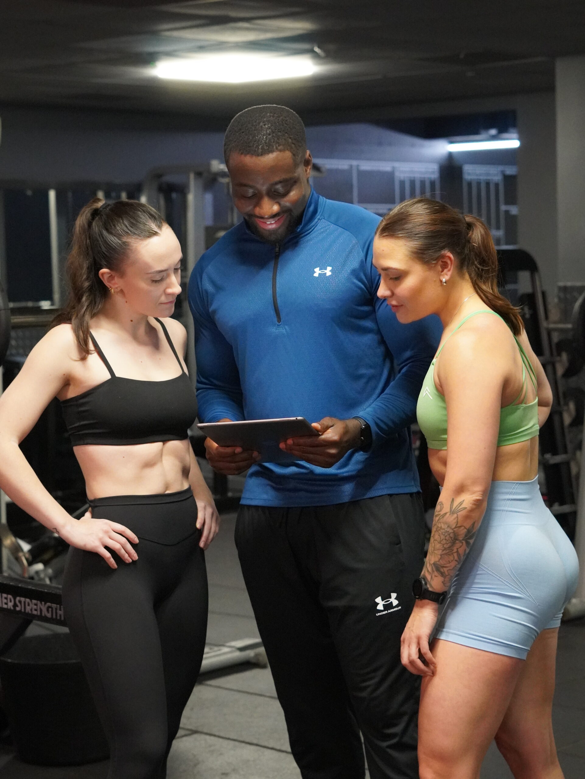 Man and woman in their 40s using the 12REPS strength training app during a gym workout